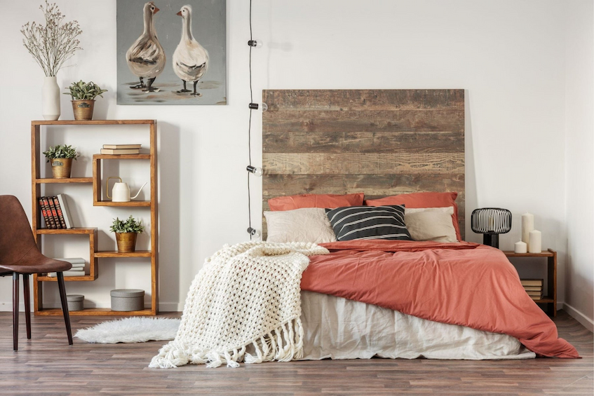 Decorated room with orange bed sheet and bookshelf