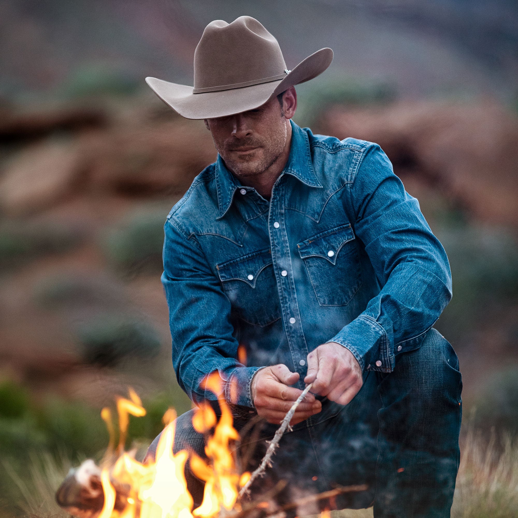 Man wearing cowboy hat and denim shirt