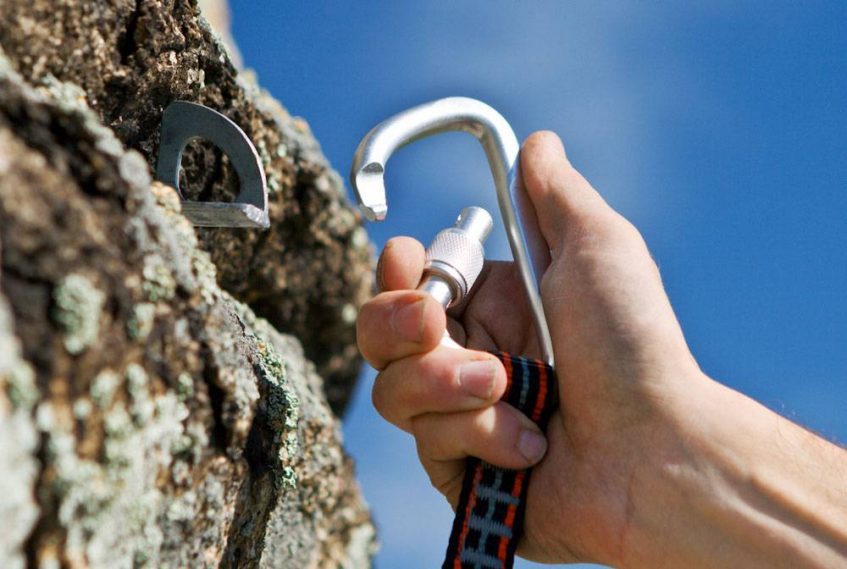 Climber setting up carabiner on a rock