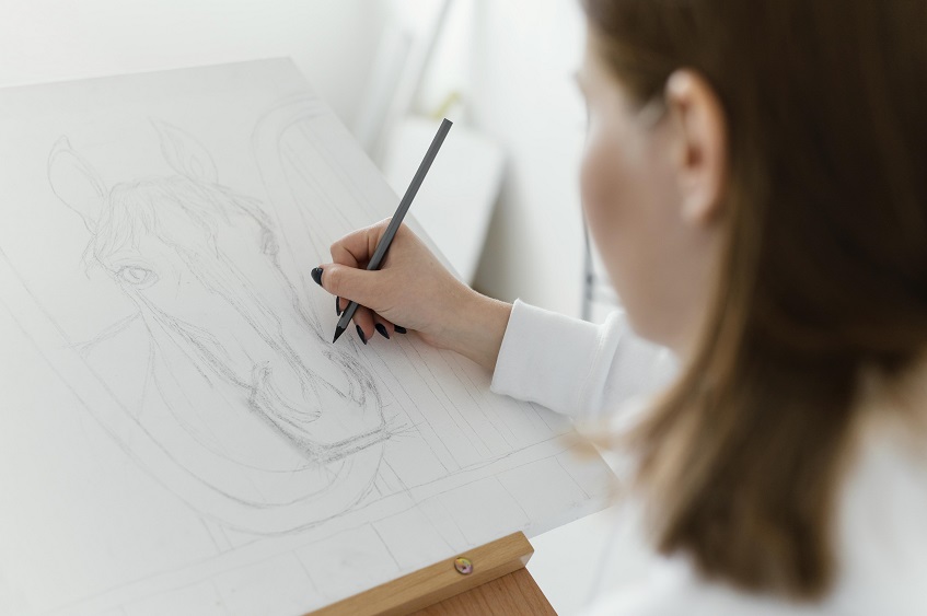 young woman drawing with pencil