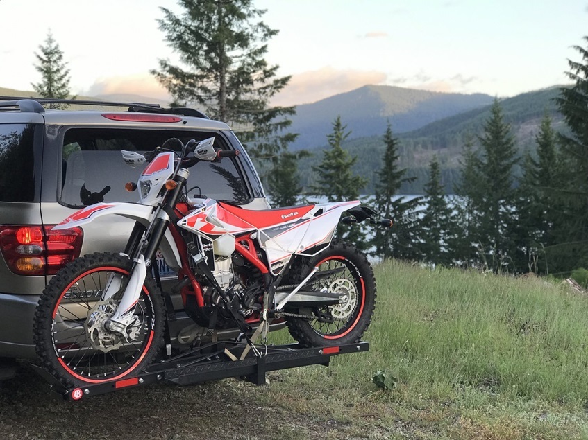 Motocross on carrier attached on SUV in nature