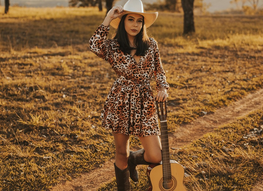 A woman dressed in a dress and cowboy boots